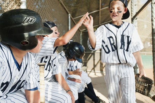 USA, California, Ladera Ranch, Boys (10-11) from little league sitting on dugout.