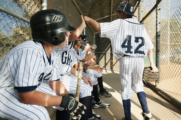 USA, California, Ladera Ranch, Boys (10-11) from little league sitting on dugout.