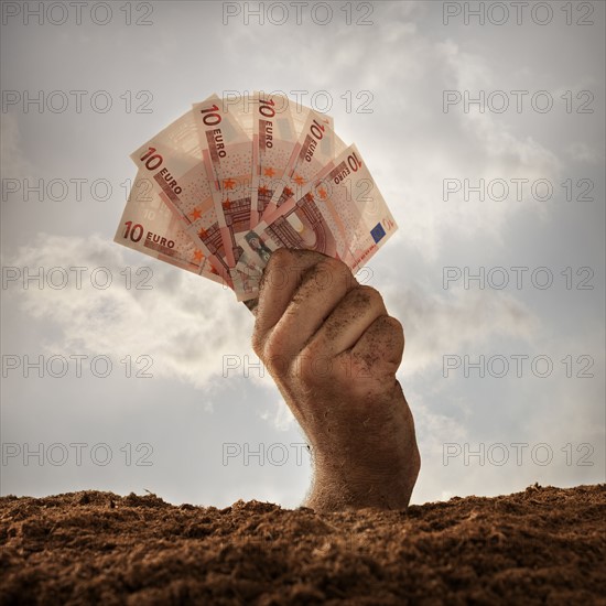 Human hand holding ten euros banknotes, studio shot. Photo : Mike Kemp