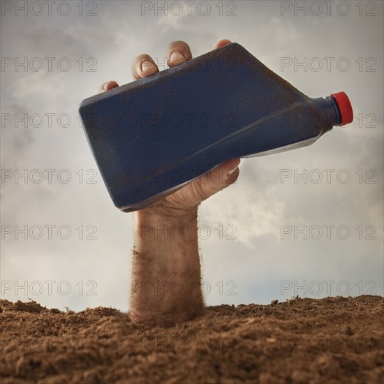 Human hand holding plastic bottle, studio shot. Photo : Mike Kemp