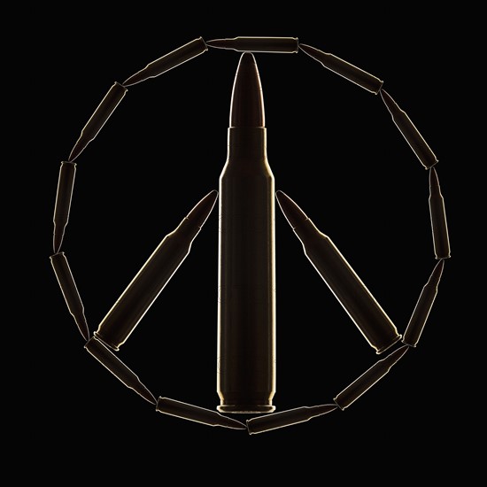 Peace Sign made of bullets on black background. Photo : Mike Kemp