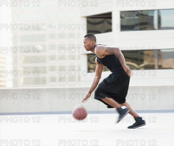 USA, Utah, Salt Lake City, Young man playing basketball. Photo : Mike Kemp