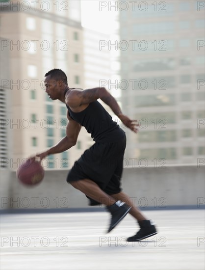 USA, Utah, Salt Lake City, Young man playing basketball. Photo : Mike Kemp