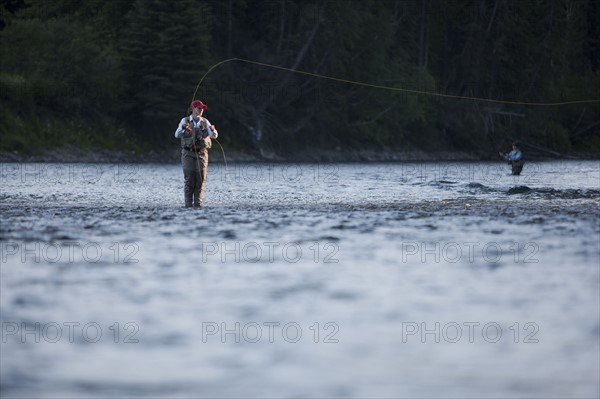 Canada, British Columbia, Fernie, Woman fly fishing in river. Photo : Dan Bannister