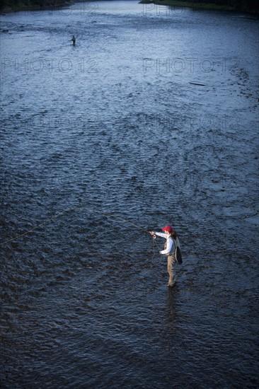 Canada, British Columbia, Fernie, Woman fly fishing in river. Photo : Dan Bannister