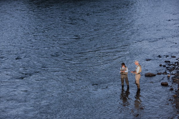 Canada, British Columbia, Fernie, Couple fly fishing in river. Photo : Dan Bannister