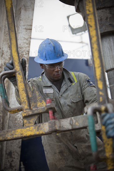 Oil worker drilling for oil on rig. Photo : Dan Bannister