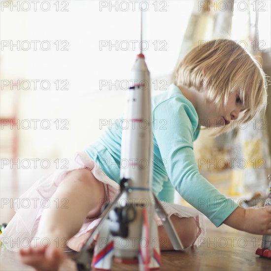 Petite fille jouant avec des robots et une fusée