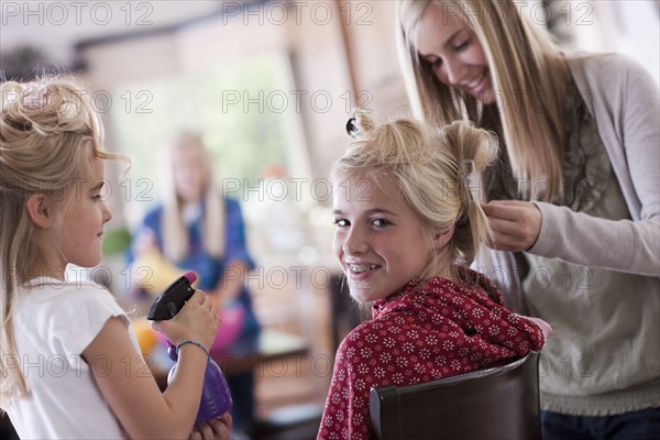 USA, Utah, family portrait of sisters (6-7, 8-9, 12-13, 14-15, 16-17) preparing hairs and having fun. Photo : Tim Pannell