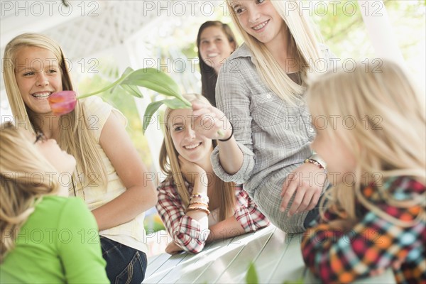 USA, Utah, family portrait of sisters (6-7, 8-9, 12-13, 14-15, 16-17) at table playing with flower. Photo : Tim Pannell