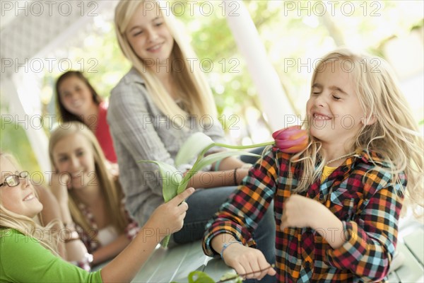 USA, Utah, family portrait of sisters (6-7, 8-9, 12-13, 14-15, 16-17) at table playing with flower. Photo : Tim Pannell
