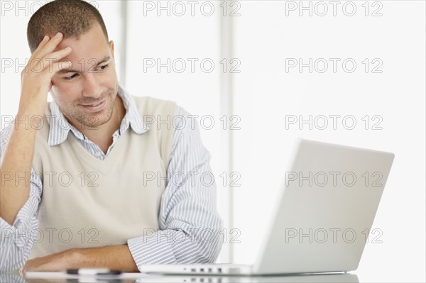 South Africa, Portrait of young man with laptop. Photo : momentimages