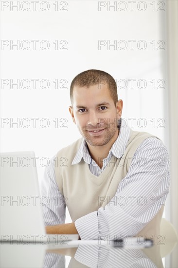 South Africa, Portrait of young man with laptop. Photo : momentimages