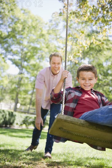 USA, New York, Flanders, Father and son (8-9) playing in garden. Photo : Jamie Grill Photography