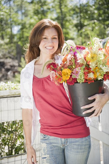 USA, New York, Flanders, Portrait of woman with bunch of flowers. Photo : Jamie Grill Photography