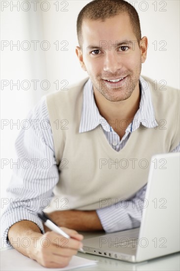 South Africa, Portrait of young man with laptop. Photo : momentimages