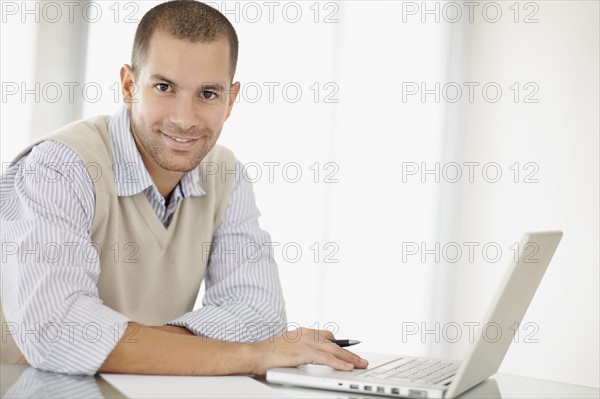 South Africa, Portrait of young man with laptop. Photo : momentimages