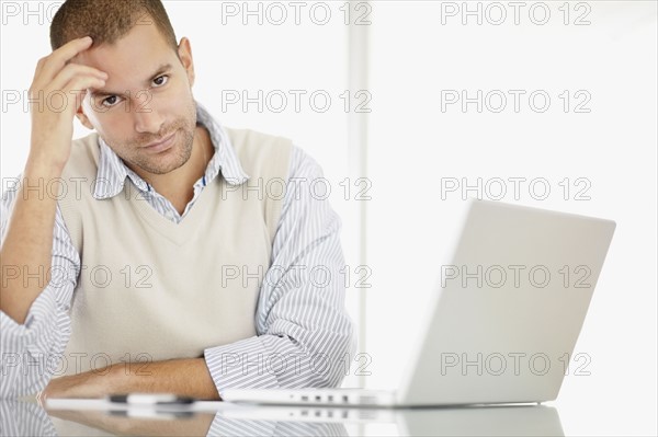 South Africa, Portrait of young man with laptop. Photo : momentimages