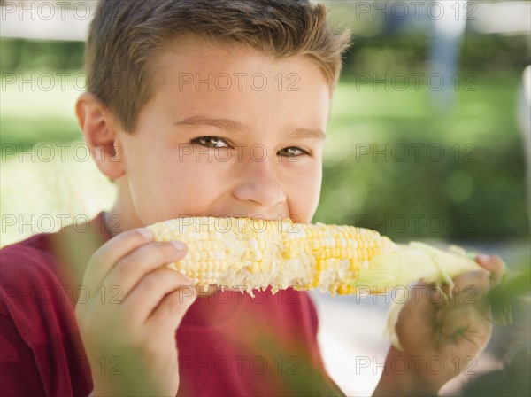 USA, New York, Flanders, Boy (8-9) eating corn. Photo : Jamie Grill Photography