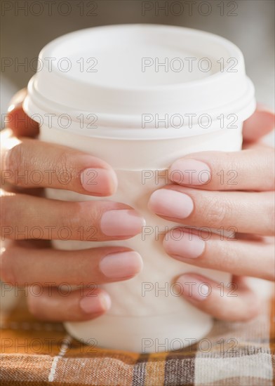 USA, New Jersey, Jersey City, Close-up view of woman's hands holding takeaway coffee. Photo : Jamie Grill Photography