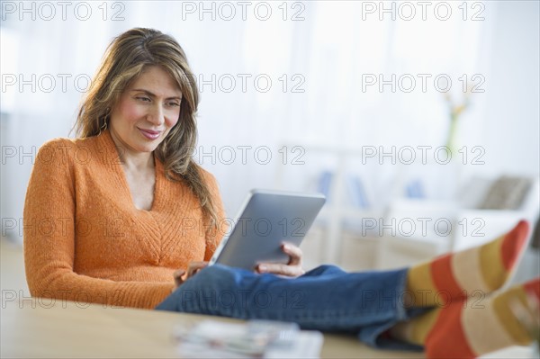 USA, New Jersey, Jersey City, Woman using digital tablet on sofa.