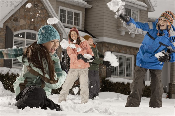 USA, Utah, Provo, Boys (10-11, 12-13) and girls (10-11, 16-17) having snow ball fight in front of house. Photo : FBP