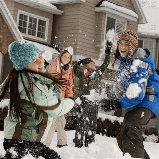 USA, Utah, Provo, Boys (10-11, 12-13) and girls (10-11, 16-17) having snow ball fight in front of house. Photo : FBP
