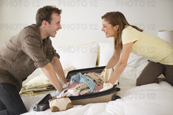 USA, New Jersey, Jersey City, Portrait of young couple packing clothes.