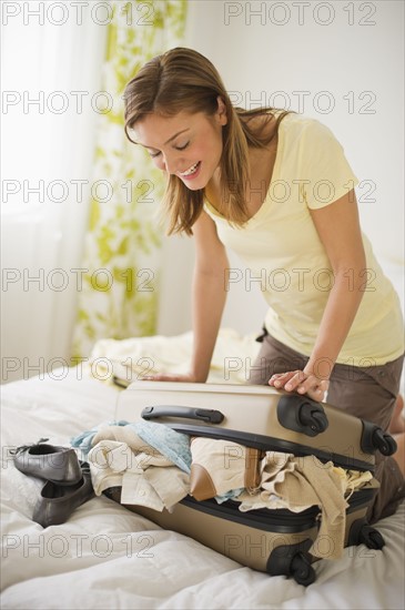 USA, New Jersey, Jersey City, Portrait of young woman packing clothes.