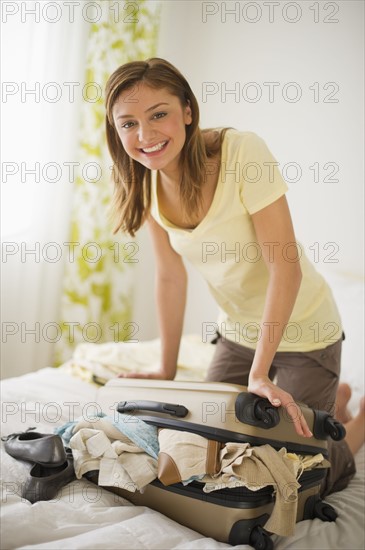 USA, New Jersey, Jersey City, Portrait of young woman packing clothes.