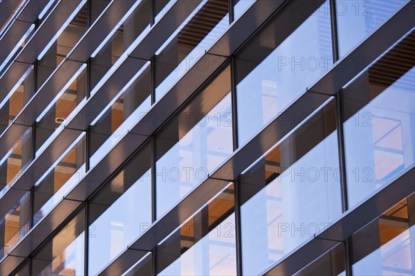 USA, New York, New York City, Reflections in windows of office block.