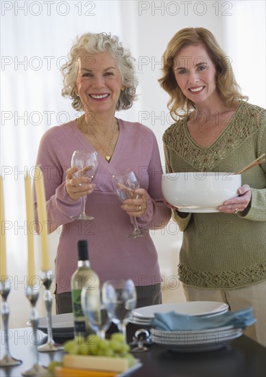 USA, New Jersey, Jersey City, Portrait of mother and daughter setting table in home.