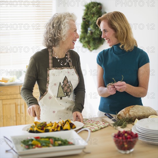 USA, New Jersey, Jersey City, Mother and daughter preparing food in kitchen.