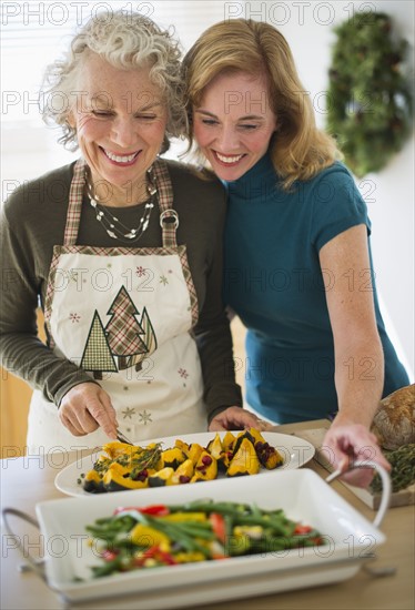 USA, New Jersey, Jersey City, Mother and daughter preparing food in kitchen.