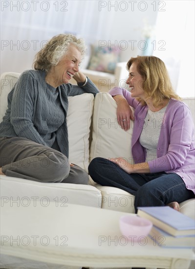USA, New Jersey, Jersey City, Mother and daughter talking on sofa.