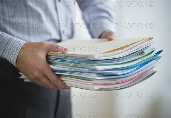 USA, New Jersey, Jersey City, Businessman carrying paperwork.