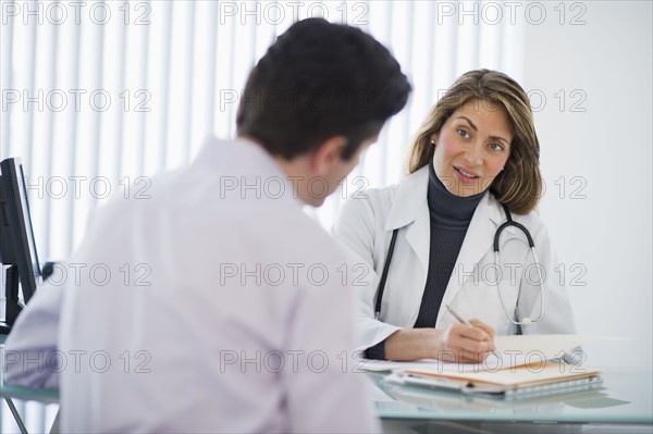 USA, New Jersey, Jersey City, Female doctor talking with male patient in office.