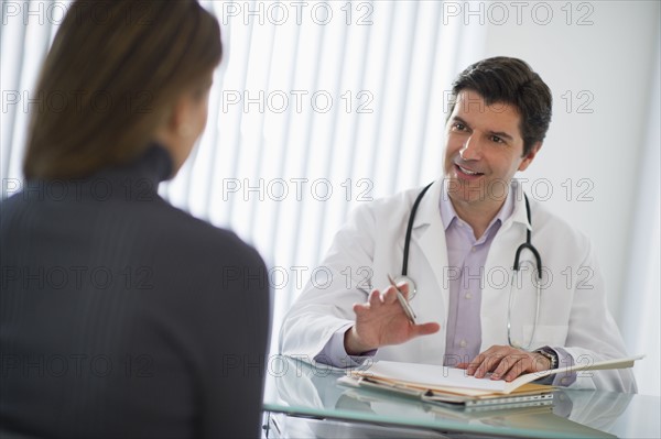 USA, New Jersey, Jersey City, Doctor talking with female patient in office.