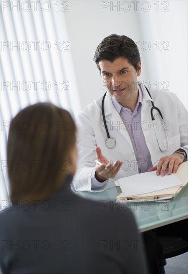 USA, New Jersey, Jersey City, Doctor talking with female patient in office.