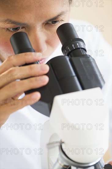 USA, New Jersey, Jersey City, Female scientist using microscope.