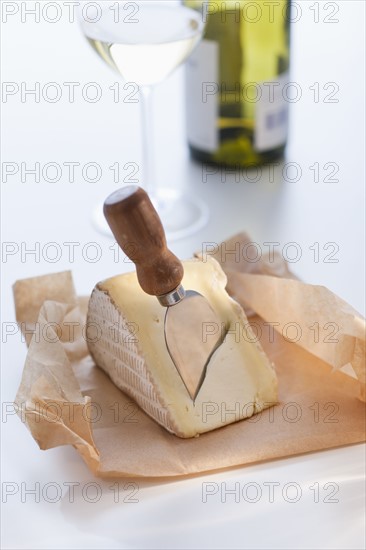 Slice of brie with cheese knife.