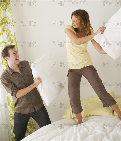 USA, New Jersey, Jersey City, Portrait of young couple fighting with pillow.