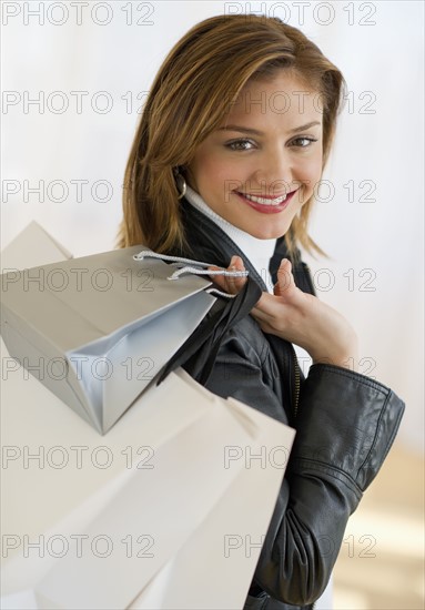 USA, New Jersey, Jersey City, Portrait of young woman with shopping bags.