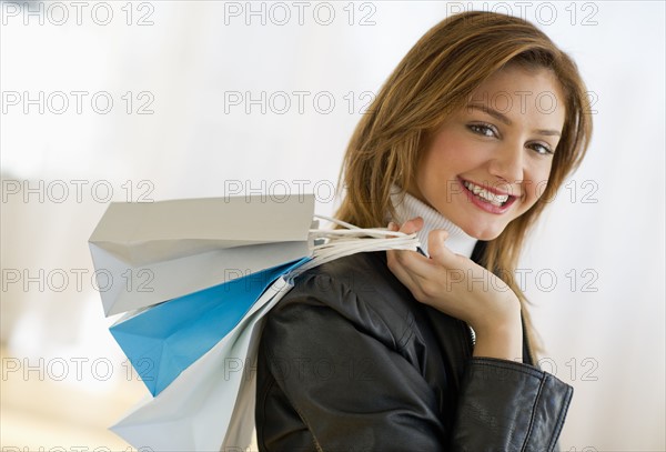 USA, New Jersey, Jersey City, Portrait of young woman with shopping bags.