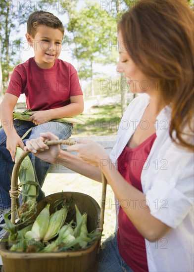 USA, New York, Flanders, Mother and son (8-9) with basket of corns. Photo : Jamie Grill Photography