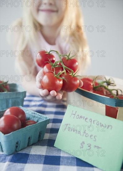 USA, New Jersey, Jersey City, Gil (8-9) showing home grown tomatoes. Photo : Jamie Grill Photography
