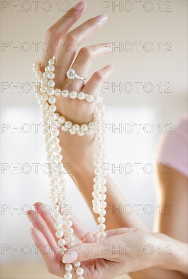 USA, New Jersey, Jersey City, Woman's hand holding pearl beads. Photo : Jamie Grill Photography