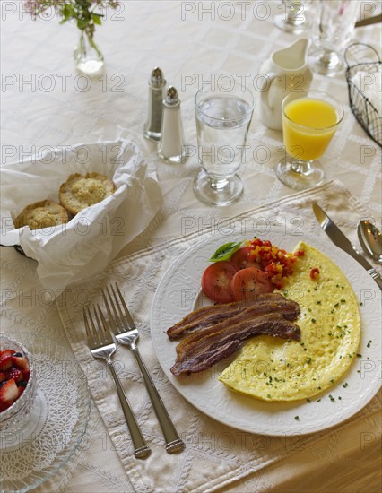 Bacon and omelet on breakfast table.