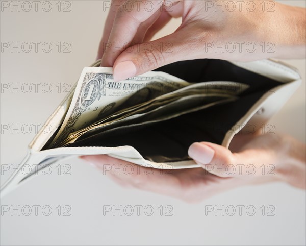 USA, New Jersey, Jersey City, Close-up view of pulling one dollar note from wallet. Photo : Jamie Grill Photography