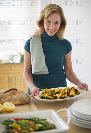 USA, New Jersey, Jersey City, Portrait of woman preparing food in kitchen.